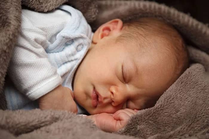 Closeup portrait of baby sleeping covered in blanket